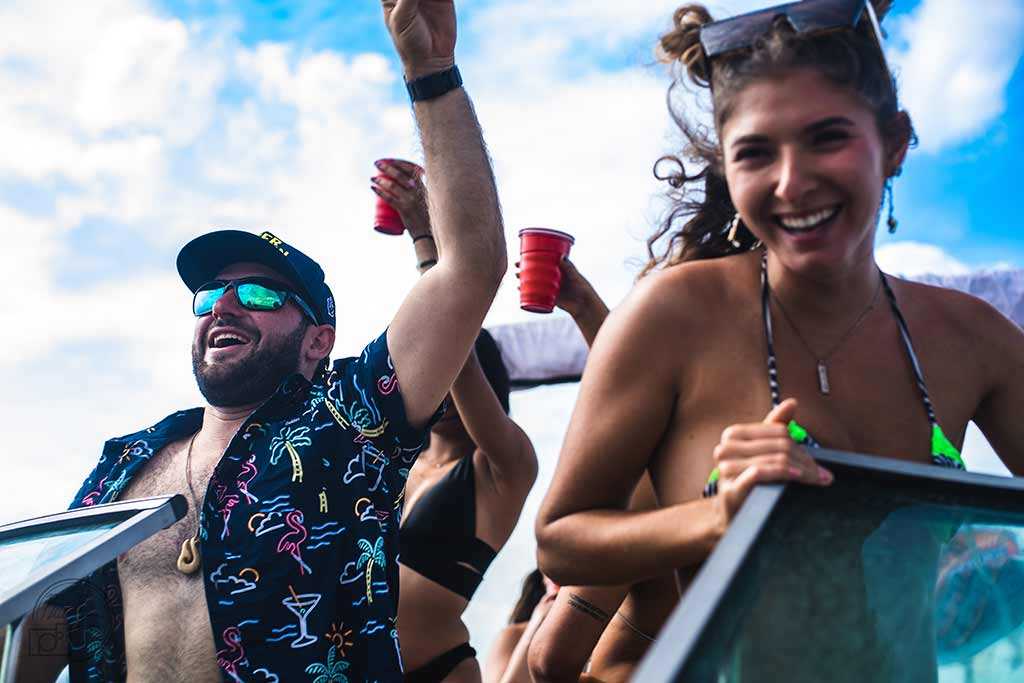 Beautiful girl on party boat with guys holding drinks in Tampa, FL.