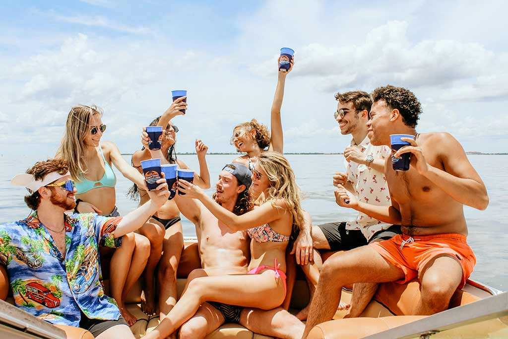 Friends with drinks and a girl in a guy's lap on a party boat near Tampa, FL.