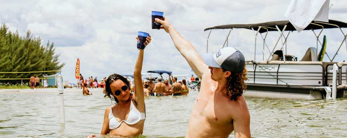 Hot girl and guy holding up drinks in Tampa Bay, FL.