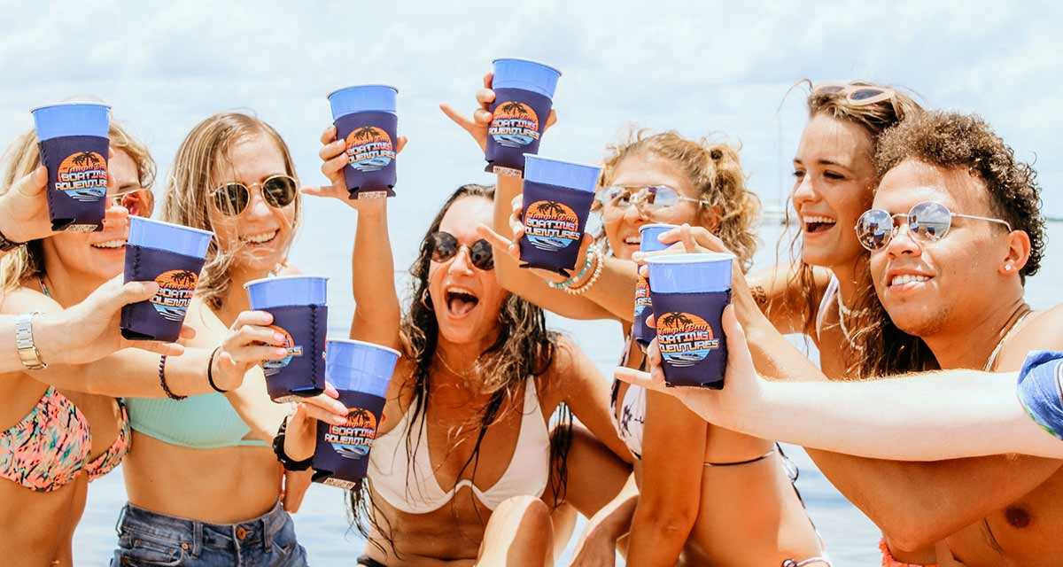 Girls and guys with drinks on a party boat in Tampa Bay, FL.