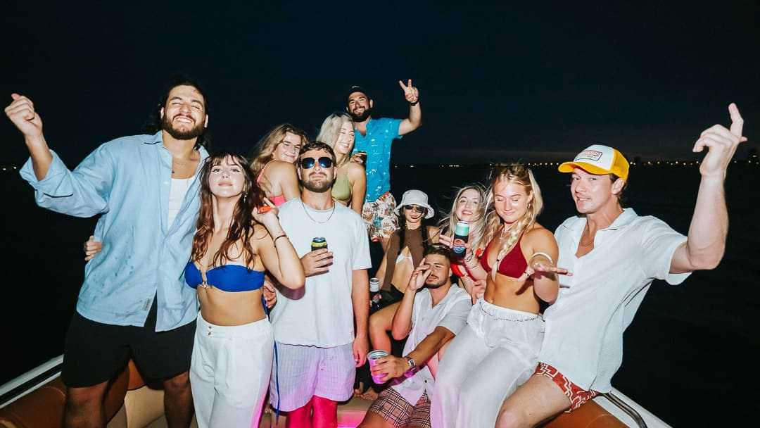 Guests celebrating together on the boat at night.
