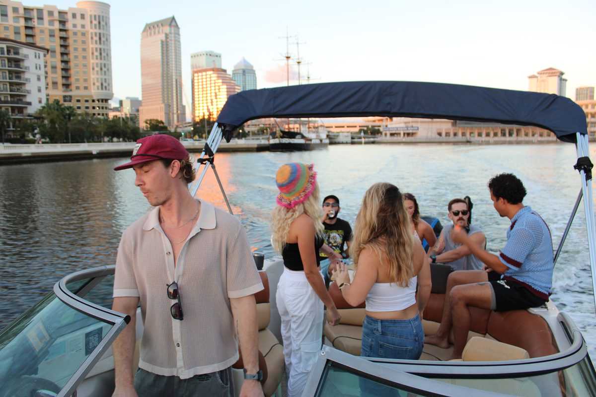 Large group under the bimini with the downtown Tampa skyline behind them.