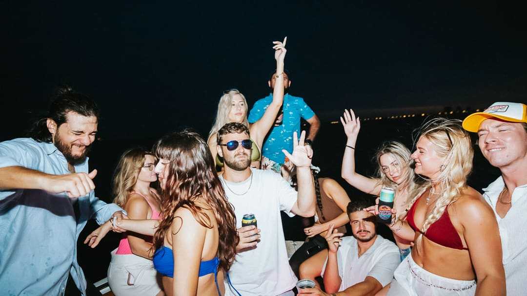 Friends dancing together on the boat at night.