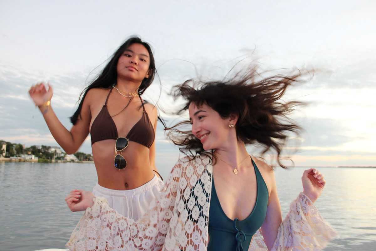 Two friends dancing on the bow on open water off Davis Island.