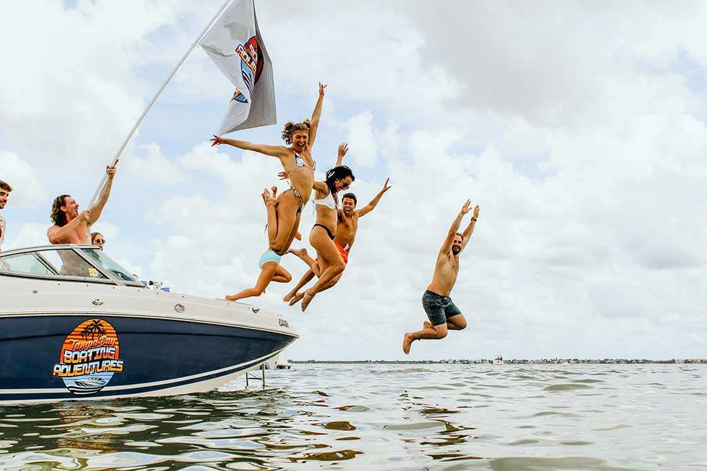 Friends jumping off a party boat in Tampa Bay, Florida.