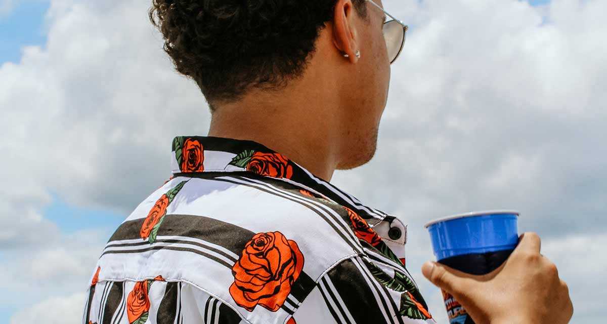 Young man with a drink looking out over Tampa Bay, FL.