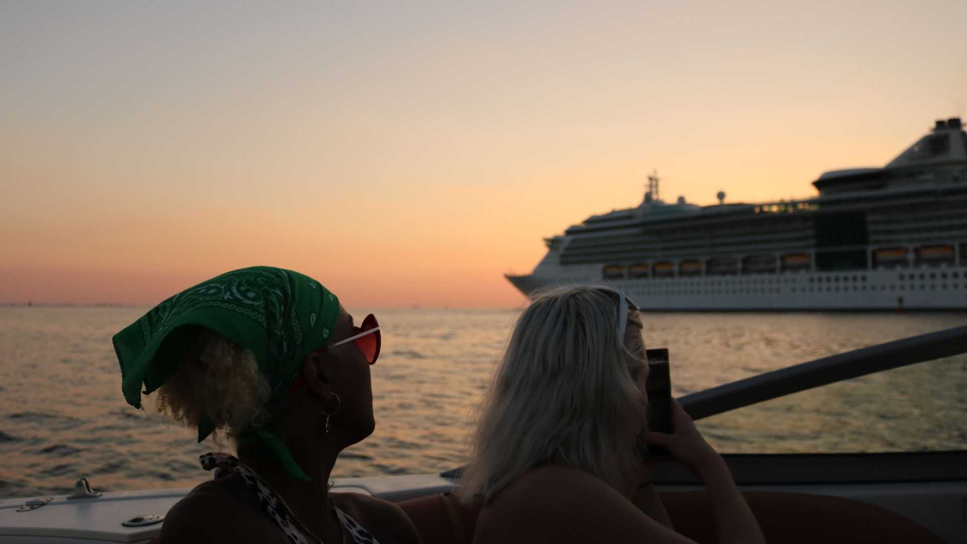 Sunset cruise in Tampa Bay with golden sky and city lights.