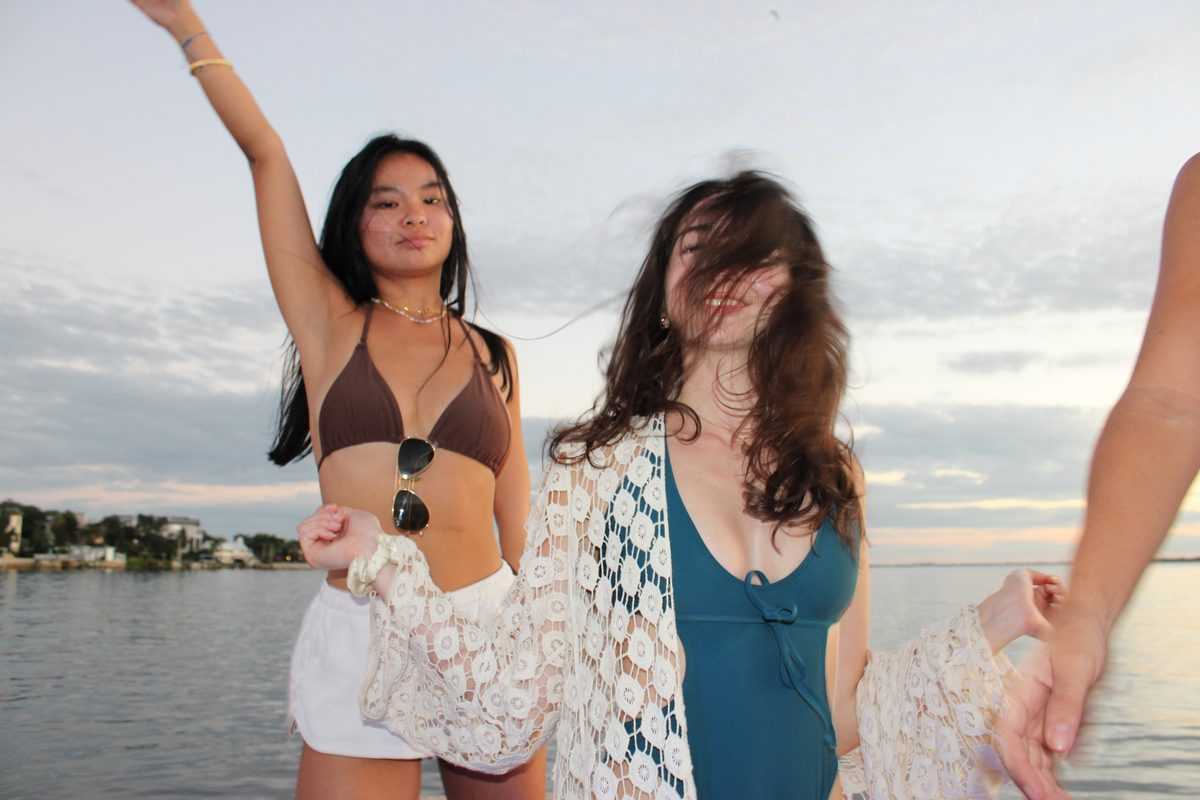 Two friends dancing on the bow at sunset on Tampa Bay.