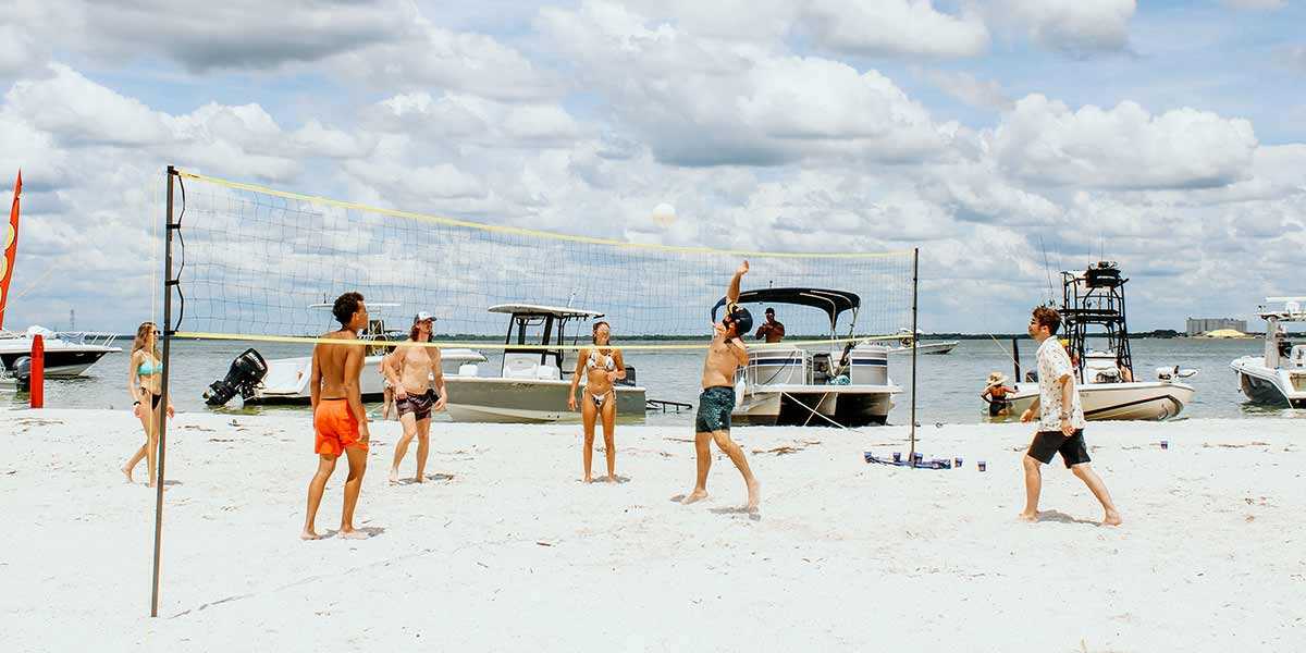 Partiers playing volleyball on the beach at Beer Can Island in Florida.