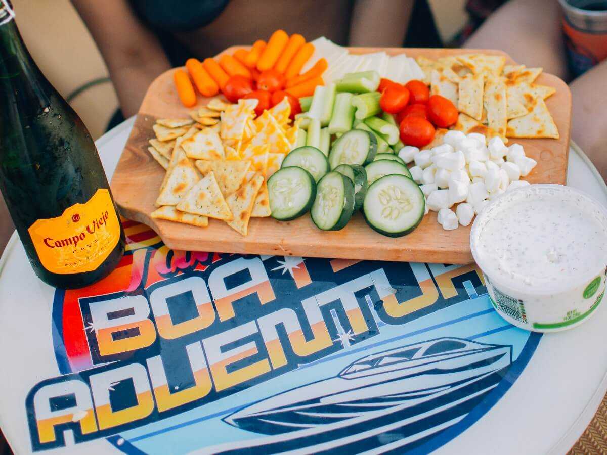 Charcuterie board and champagne set out on the boat table.