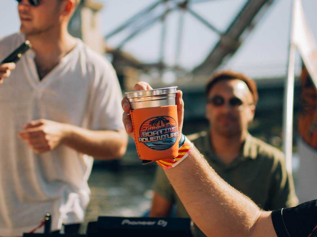 Guest holding up a TBBA koozie on board.