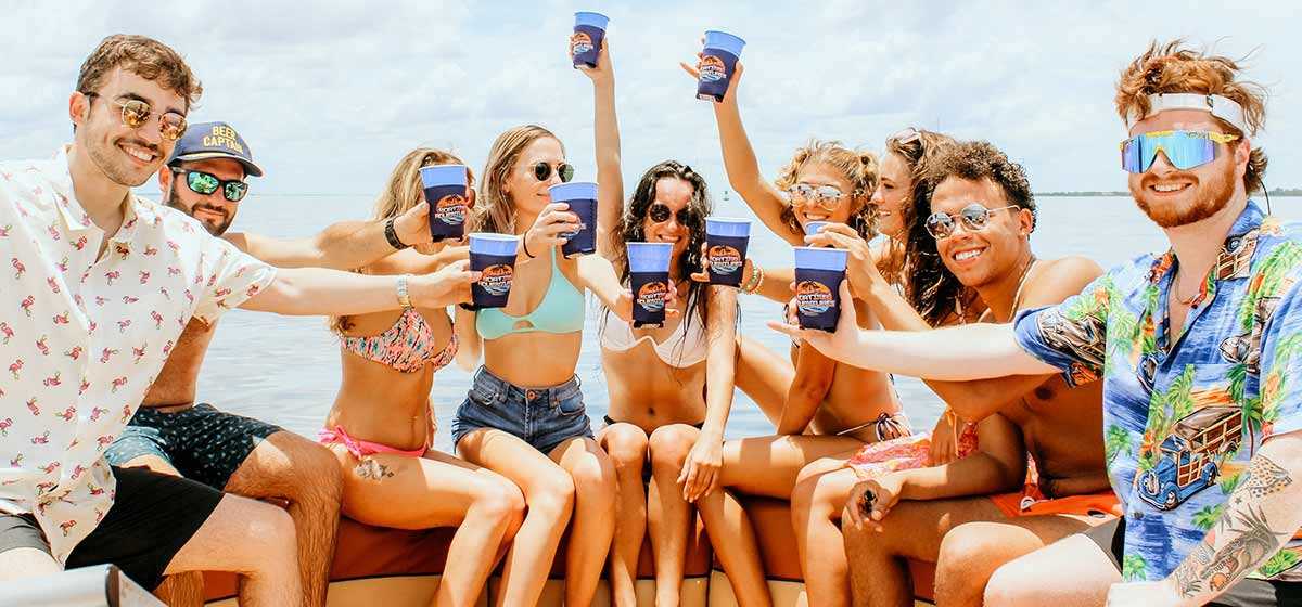 Friends raising drinks on a private party boat in Tampa Bay.