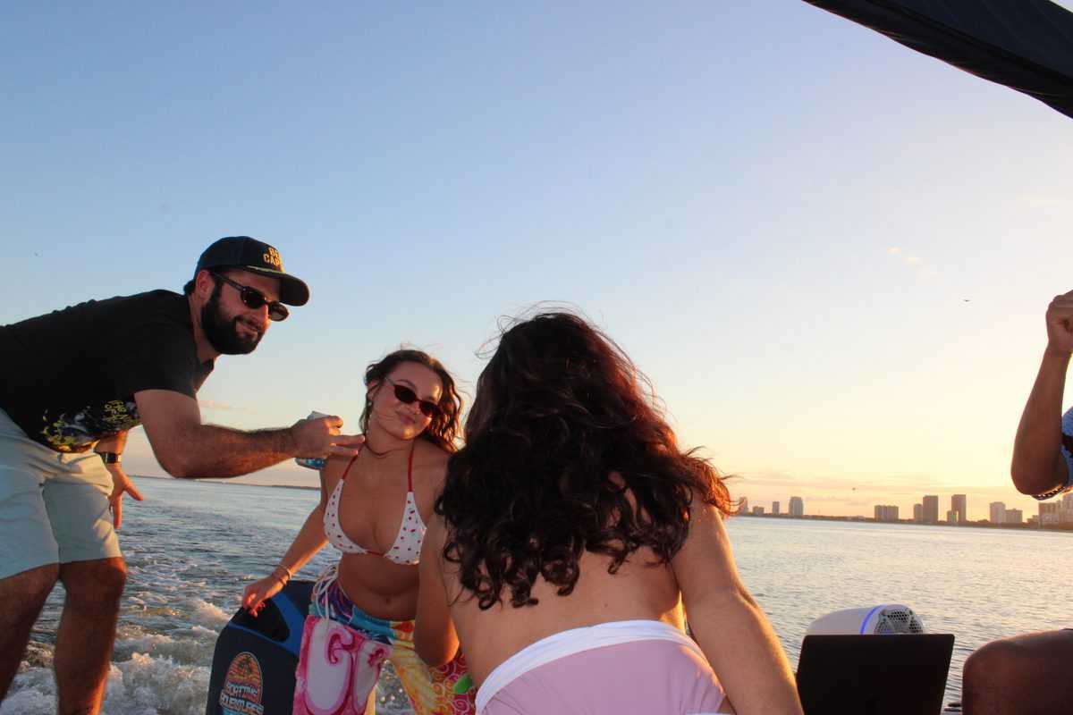 Three friends laughing at sunset off Harbour Island.