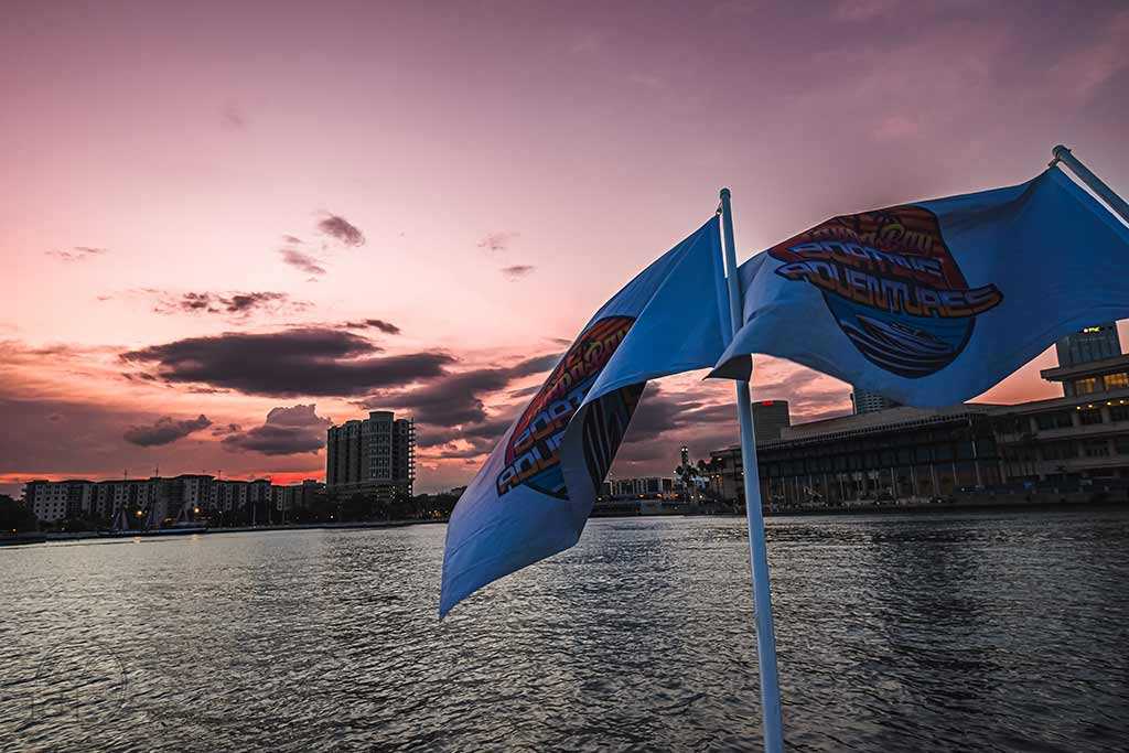 Party boat flags in Tampa Bay, FL at sunset.