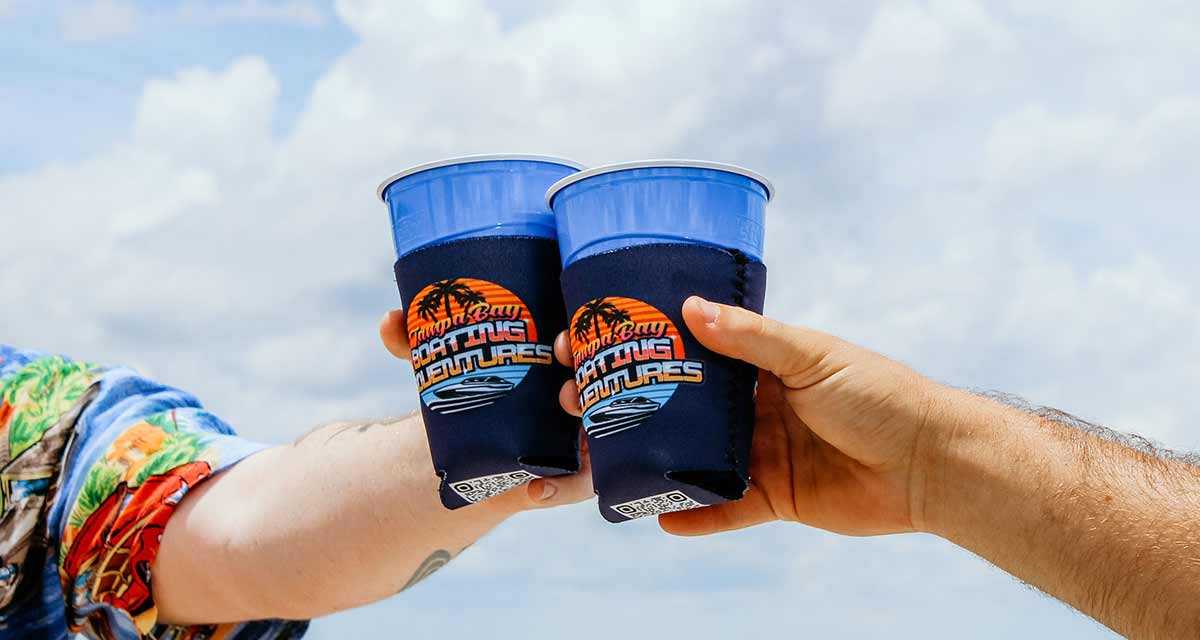 Partiers bumping cups on a party boat in Tampa Bay, FL.