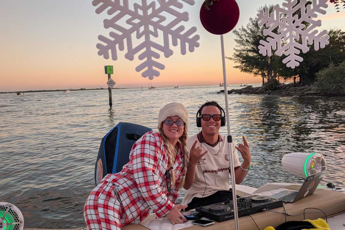 Friends under the Christmas garland at sunset on the decorated boat.
