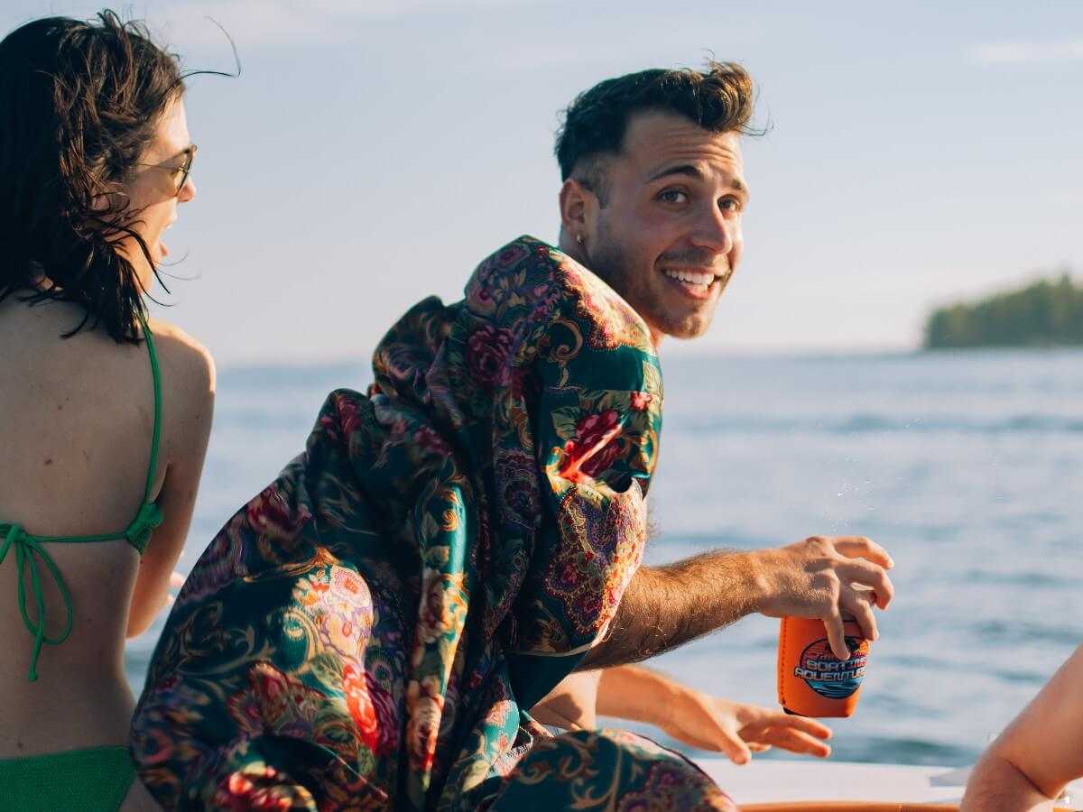 Guest smiling with a koozie, Tampa skyline behind.